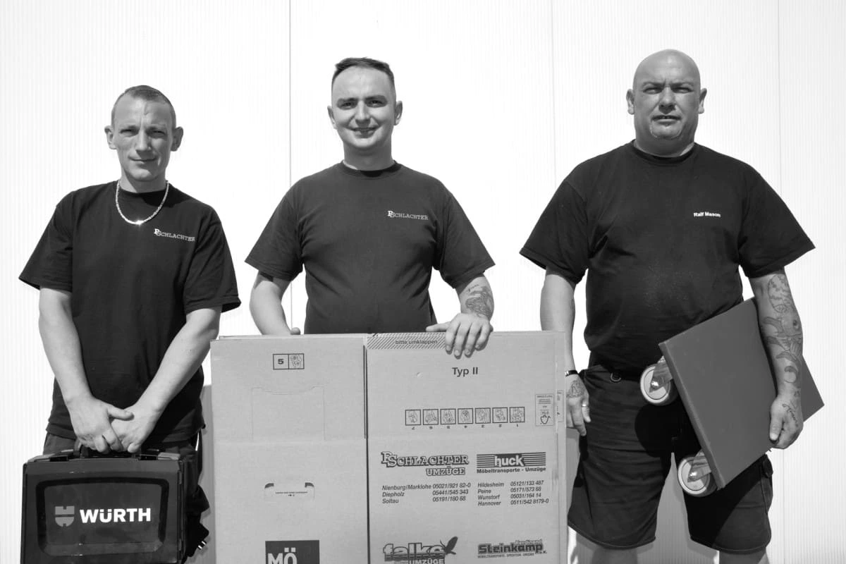 Drei Männer mit Karton