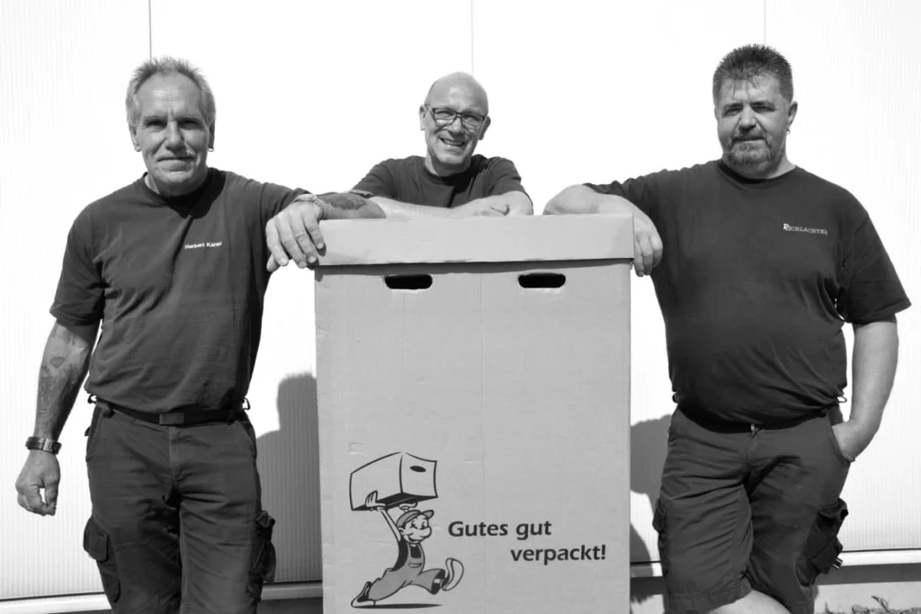 3 Möbelpacker mit Kleiderkarton