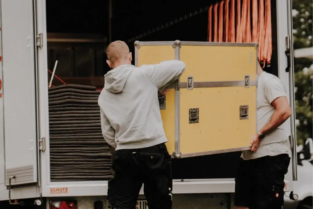 Mitarbeiter verladen eine Transportkiste für den IT-Umzug